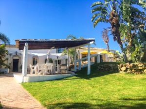 a villa with a patio and palm trees at Quinta Da Ilda in Loulé