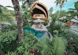 um resort com piscina no meio de um jardim em Kayuma Villas Lombok em Selong Blanak