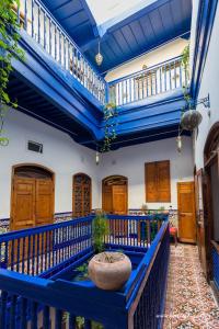 Habitación con puertas de madera y barandilla azul. en Dar Halima en Essaouira