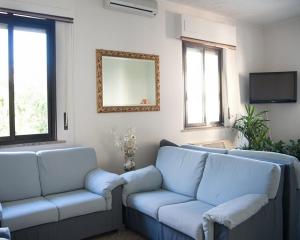 a living room with blue couches and a mirror at Hotel Perugina in Chianciano Terme