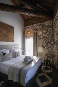 a bedroom with a large bed and a window at Demeure Terrisse La Résidence in Marseillan