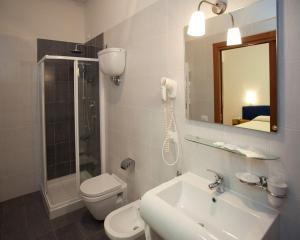 a bathroom with a sink and a toilet and a mirror at Hotel Perugina in Chianciano Terme