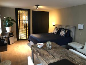 a bedroom with a bed and a table in a room at B&B de Nieuwe Haven in Bunschoten