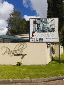 a sign for a guest house in front of a building at Pablo Guesthouse in Ermelo