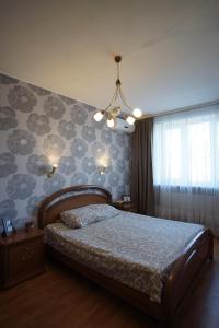 ein Schlafzimmer mit einem Bett und einer Wand mit Blumen in der Unterkunft Mironositskaya street in Kharkov