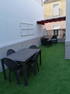une table et des chaises sur une terrasse avec de l'herbe verte dans l'établissement Atico Duque Gran Terraza Parking Free, à Carthagène