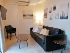 a living room with a black couch and a table at Atico Duque Gran Terraza Parking Free in Cartagena