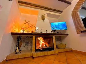 sala de estar con chimenea y TV en Grazalema- Casita Panorama - Fantastic views- Clima & Wi-Fi, en Grazalema