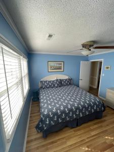 1 dormitorio con cama y pared azul en Beach Breeze 3, pet friendly, walking distance to Atlantic Ocean free parking, en Myrtle Beach