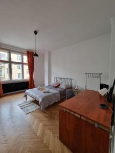 Big and cozy bedroom in Krakow في كراكوف: غرفة نوم بسرير وارضية خشبية