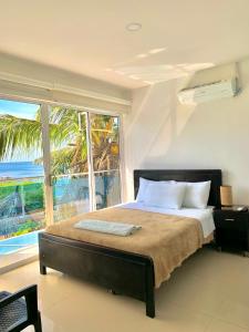 a bedroom with a bed with a view of the ocean at Hostal Viña del Mar in Taganga