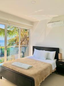 a bedroom with a large bed with a large window at Hostal Viña del Mar in Taganga