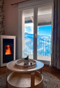 un soggiorno con tavolo e una grande finestra di Apartamentos Vista Sierra Nevada a Sierra Nevada