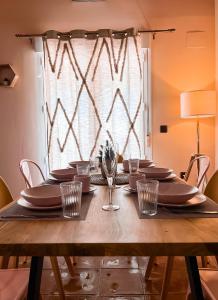 a wooden table with plates and wine glasses on it at Apartamentos Vista Sierra Nevada in Sierra Nevada