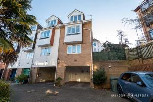 un gran edificio con un garaje delante en BMTH town centre 2 min walk, 3 bed house, outside space and parking - Driftwood, en Bournemouth