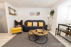 uma sala de estar com um sofá e uma mesa em BMTH town centre 2 min walk, 3 bed house, outside space and parking - Driftwood em Bournemouth