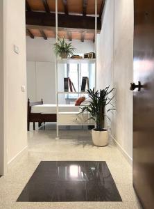 a living room with a bed and a table with a plant at XX Settembre Studio Apartment in Parma