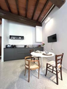 a living room with a table and chairs and a kitchen at XX Settembre Studio Apartment in Parma