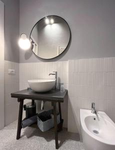 a bathroom with a sink and a mirror and a tub at XX Settembre Studio Apartment in Parma