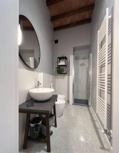 a bathroom with a sink and a toilet and a mirror at XX Settembre Studio Apartment in Parma