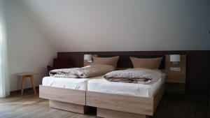 a bedroom with two beds and a wooden headboard at Gästehaus Winzerhof am Schlierbach 