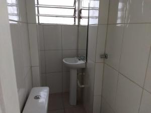 een badkamer met een wastafel, een toilet en een raam bij ANNANDA in Florianópolis