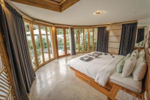 a bedroom with a bed in a room with windows at Kayuma Villas Lombok in Selong Belanak