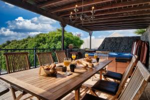 a wooden table with glasses of wine on a deck at Casa El Paraiso - Private Pool, Jacuzzi, Air-con and BBQ By Lanzarote Vacation Homes in Tías