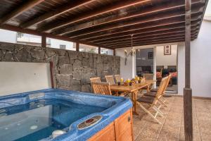 a dining room with a hot tub in a house at Casa El Paraiso - Private Pool, Jacuzzi, Air-con and BBQ By Lanzarote Vacation Homes in Tías