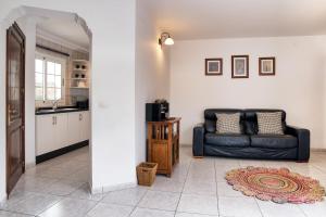 a living room with a couch and a kitchen at Casa El Paraiso - Private Pool, Jacuzzi, Air-con and BBQ By Lanzarote Vacation Homes in Tías +43 photos
