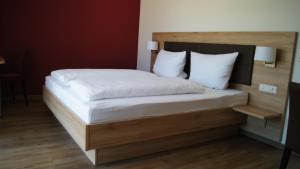 a bedroom with a bed with a wooden headboard at Gästehaus Winzerhof am Schlierbach 