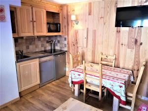 eine Küche mit einem Tisch und Stühlen sowie eine Küche mit einem Herd in der Unterkunft Duplex rénové 4 pers. avec terrasse - Résidence Les Chalets d'Aurouze, La Joue du Loup - FR-1-504-553 in Le Dévoluy