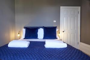 a bed with blue pillows and blue and white sheets at nap Bristol Clifton in Bristol