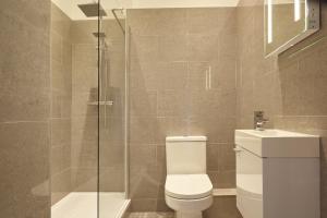 La salle de bains est pourvue de toilettes et d'une douche en verre. dans l'établissement nap Bristol Clifton, à Bristol