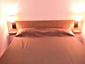 a bedroom with a white bed with two lights on it at Appartement La Joue du Loup, 2 pièces, 4 personnes - FR-1-504-573 in Le Dévoluy