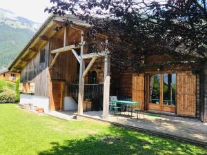 une maison en bois avec une table en face dans l'établissement Chalet Samoëns, 4 pièces, 10 personnes - FR-1-629-5, à Samoëns