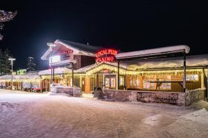 薩利色爾卡的住宿－薩利色爾卡啤酒旅館，一条雪 ⁇ 街道上带有 ⁇ 虹灯标志的建筑