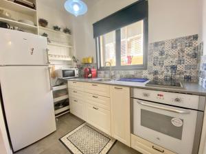 a kitchen with a white refrigerator and a sink at Lapin 9 - By Beach Apartments TLV in Tel Aviv