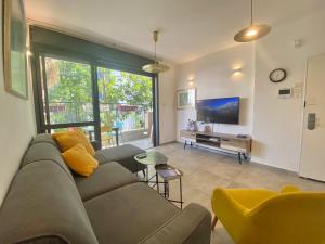 a living room with a couch and a tv at Lapin 9 - By Beach Apartments TLV in Tel Aviv