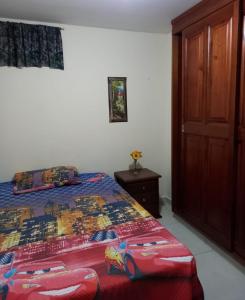 een slaapkamer met een bed met een quilt bij Casa Gloria in Medellín