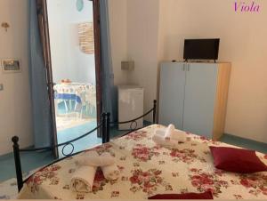 een slaapkamer met een bed, handdoeken en een koelkast bij Stella del Mattino in Lipari