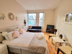 ロンドンにあるOxford Gardens Apartmentsのベッドルーム(大型ベッド1台付)、リビングルームが備わります。