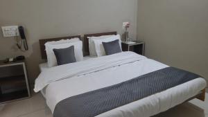 a bedroom with a large bed with white sheets and pillows at Vamoose Indrani in Chittaurgarh