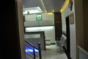 a hallway with a staircase with a chair in a building at Indrani Hotel in Chittaurgarh