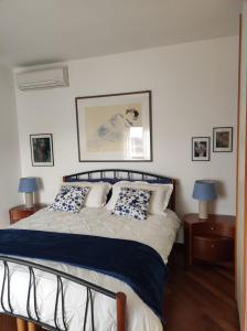 een slaapkamer met een bed met blauwe en witte kussens bij Umbriahouse in Terni