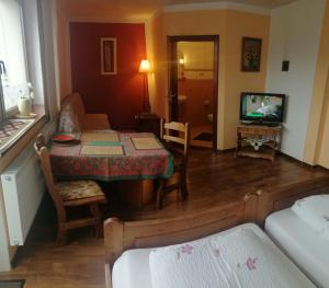 a living room with a table and a couch and a television at Villa meisterburg in Ściegny