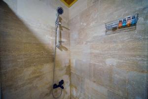 y baño con ducha y puerta de cristal. en Babili Cappadocia Cave Hotel, en Nevşehir