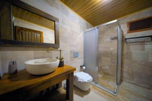 a bathroom with a white sink and a shower at Babili Cappadocia Cave Hotel in Nevşehir