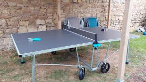 a ping pong table with a tennis racket on it at Maison avec jardin, près plages du débarquement, table ping pong, à 800 m d' Omaha beach adaptée jeunes enfants in Vierville-sur-Mer