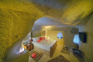 A bed or beds in a room at Babili Cappadocia Cave